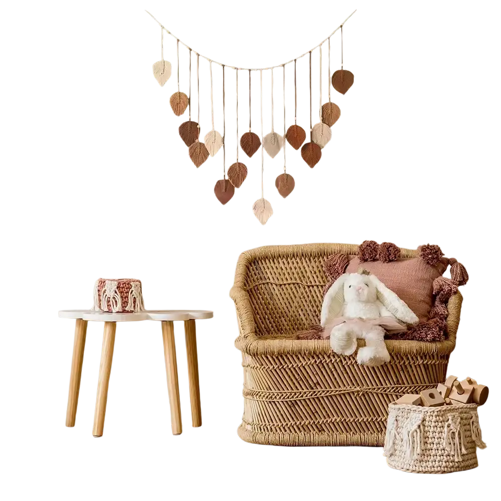 A woven rattan armchair with natural beige finish and plush pink and brown pom-pom cushions for boho decor