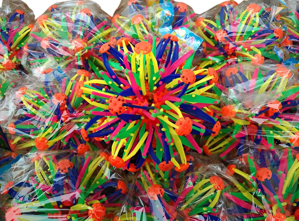Vibrant multicolored plastic spiky magic expanding ball toy with orange crab-like tops and telescopic sphere design