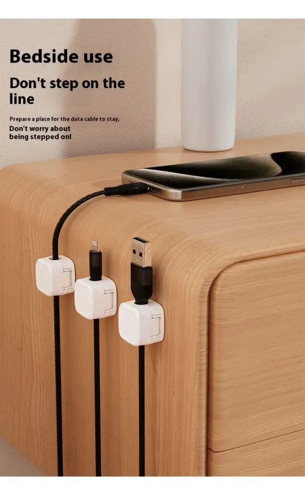 White plastic magnetic square under desk cable organizers with minimalist design holding various charging cables
