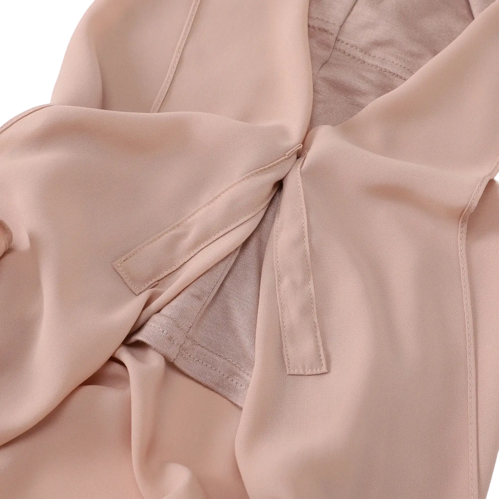 A soft blush pink satin blouse with subtle sheen and delicate stitching paired with a magnetic chiffon hijab khaki solid color