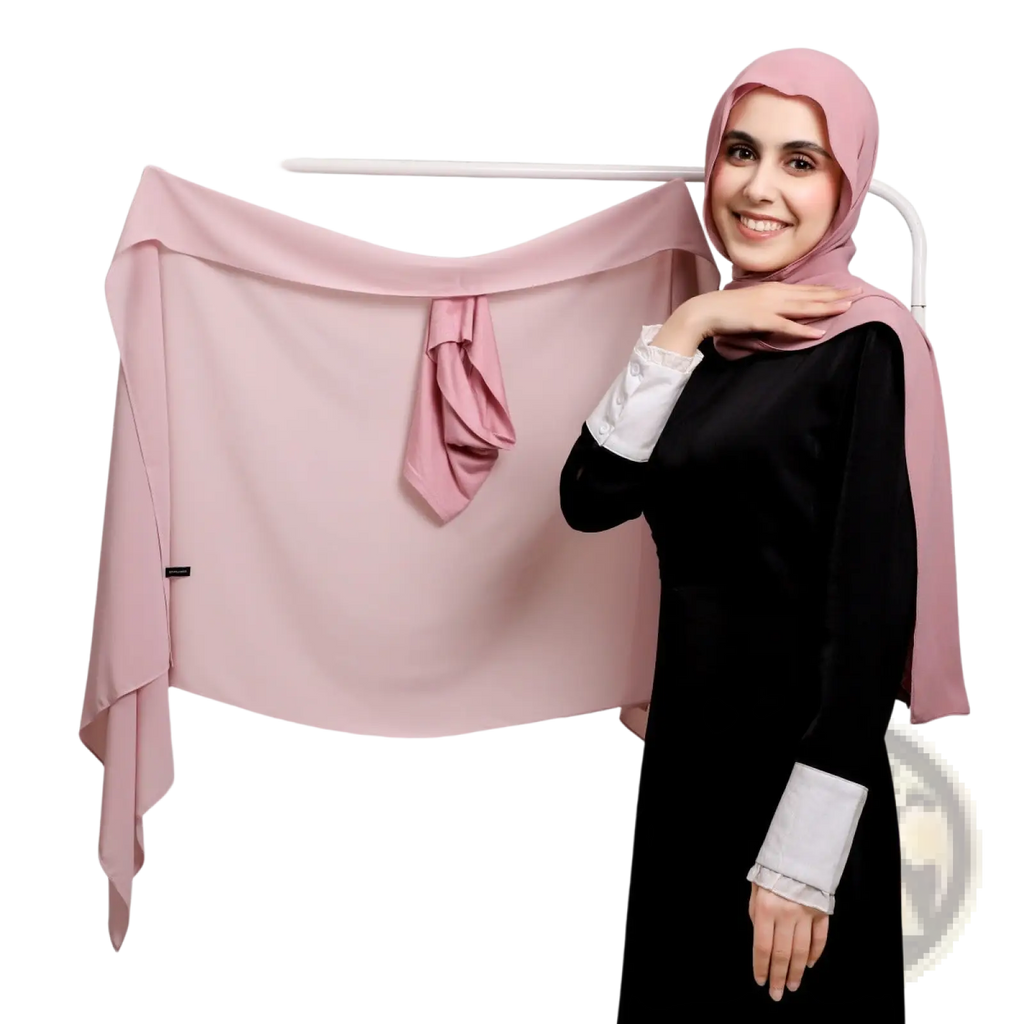 A soft dusty pink magnetic chiffon hijab made of lightweight fabric drapes elegantly over a white rack
