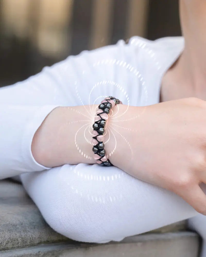 Rose quartz and magnetic hematite beaded bracelet featuring a black and pink woven design