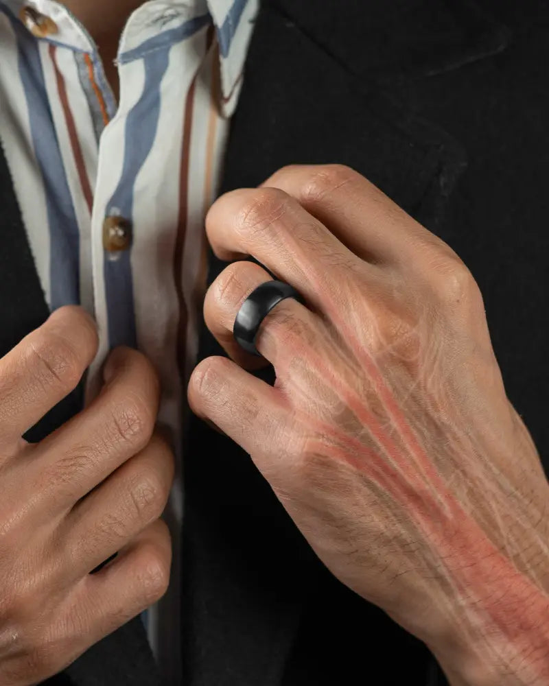 Black matte-finish brushed black stainless steel neodymium magnetic therapy ring worn on a finger