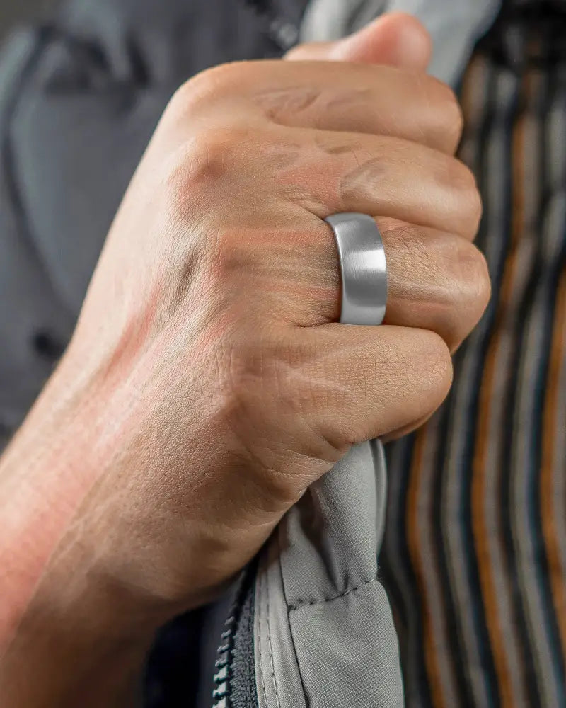 A sleek brushed silver magnetic therapy ring with neodymium magnets and a modern minimalist design worn on a finger