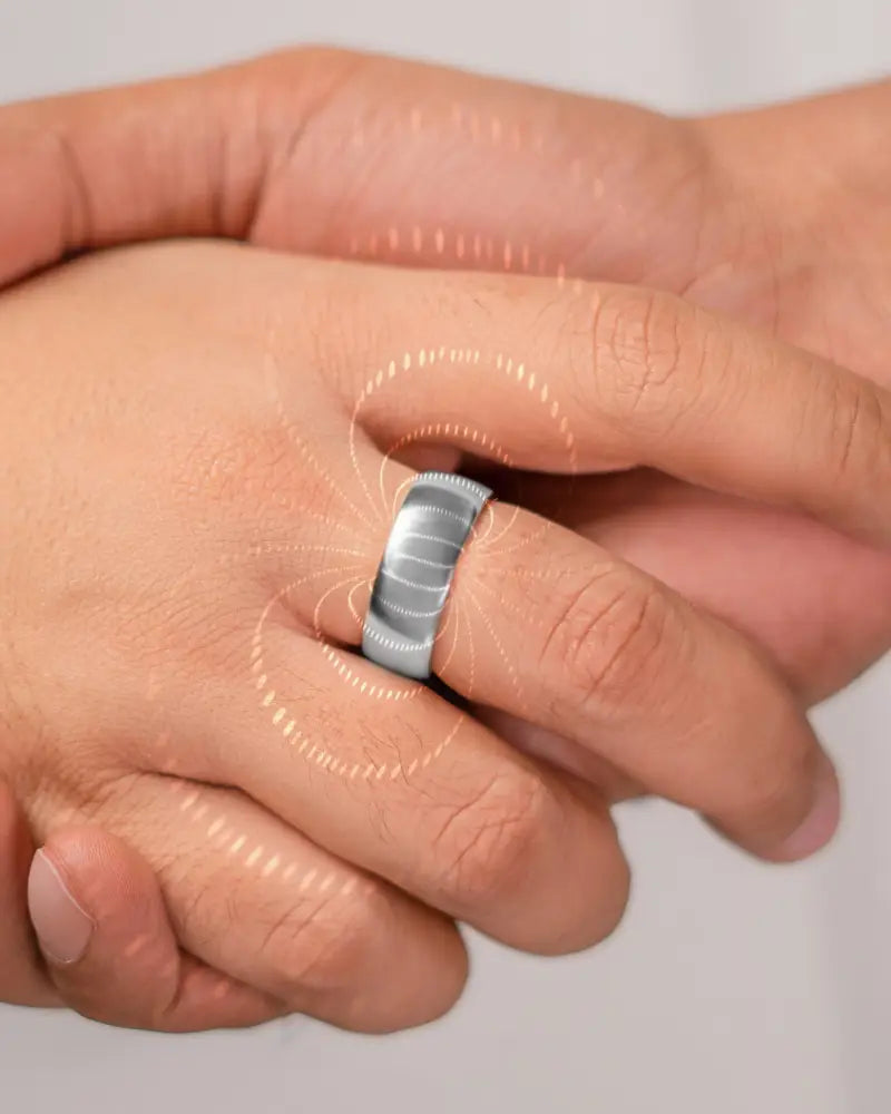 Polished silver neodymium magnetic therapy ring with textured ribbed design worn on finger in silver tone
