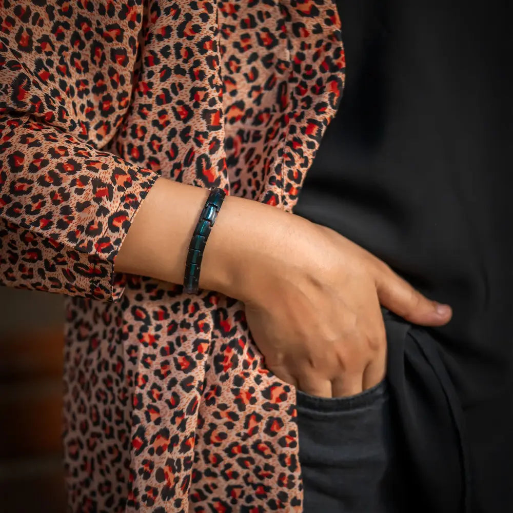 A sleek dark teal titanium thin blue line magnetic therapy bracelet with segmented rectangular design worn on wrist