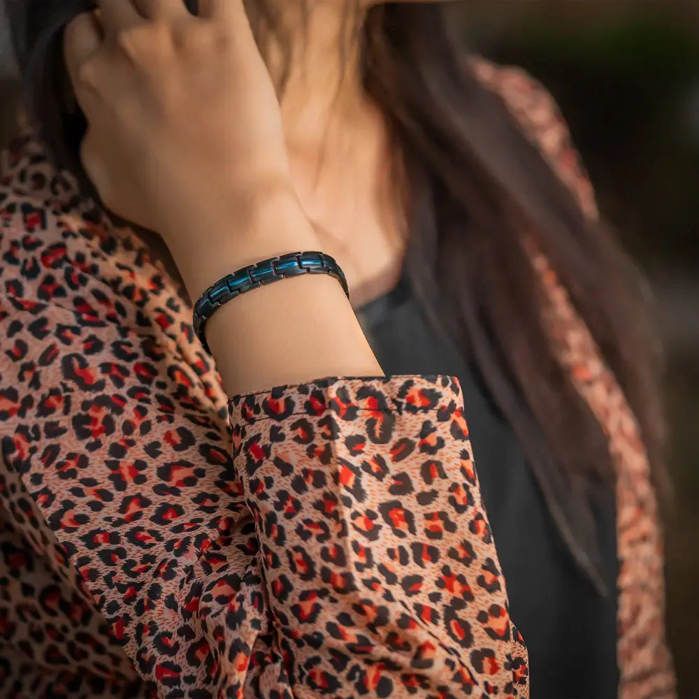 A sleek dark blue titanium thin blue line magnetic therapy bracelet with a segmented design worn on the wrist