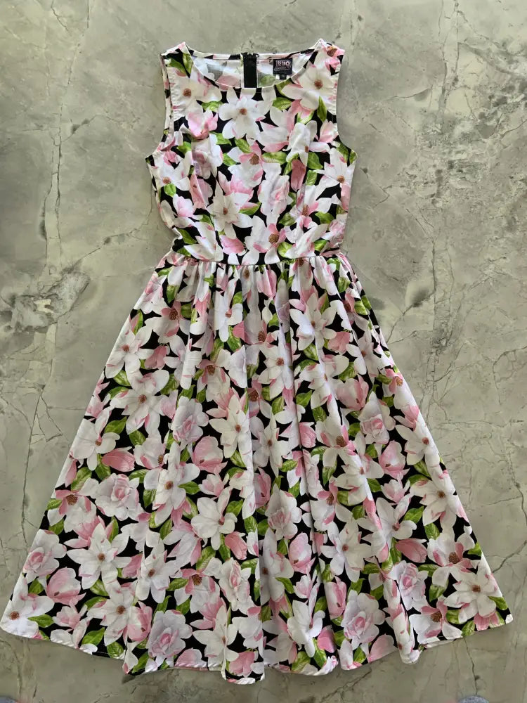 Magnolia floral cotton 1950s style midi dress with pockets featuring sleeveless black fabric with pink white blossoms and green leaves