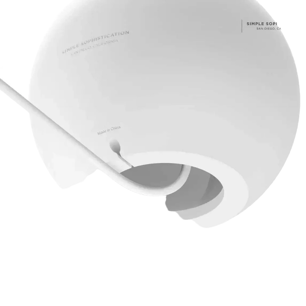 White spherical cable management device with minimalist design and smooth surface for magsafe wireless charging desk stand