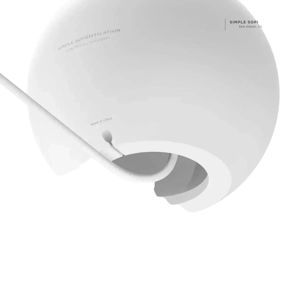 White spherical cable management device with minimalist design and smooth surface for magsafe wireless charging desk stand