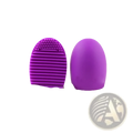 Purple silicone makeup brush cleaner egg scrubbing tool with ridged bristles and rounded handle for eyelash brushes