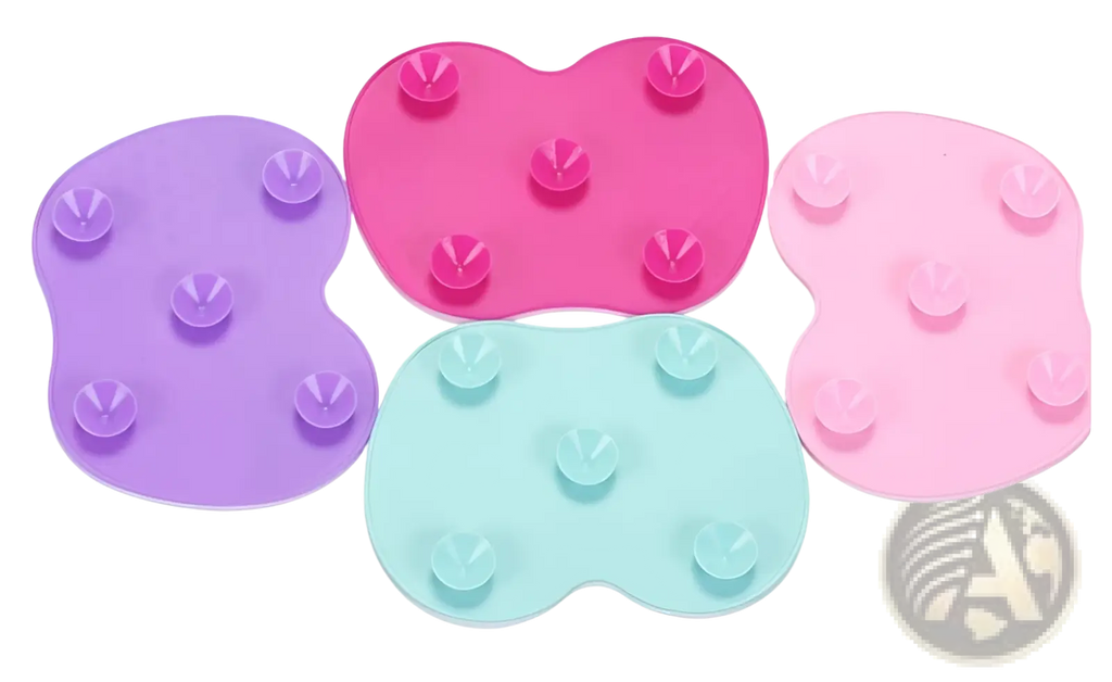 Set of four heart shaped silicone makeup brush cleaning mats in purple pink mint green and light pink with suction cups