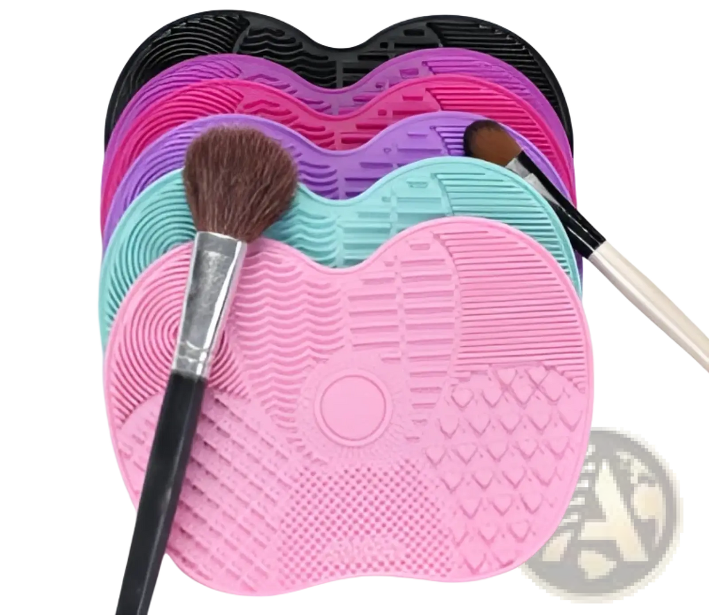 Pink silicone heart shaped makeup brush cleaning mat with textured surface and central circular indentation