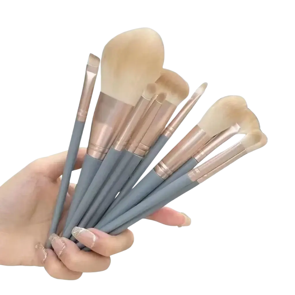 Set of eight professional synthetic makeup brushes with soft beige bristles and gray handles with rose gold ferrules