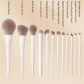 Makeup brush set with ten white handles and soft tapered bristles for diverse cosmetic applications