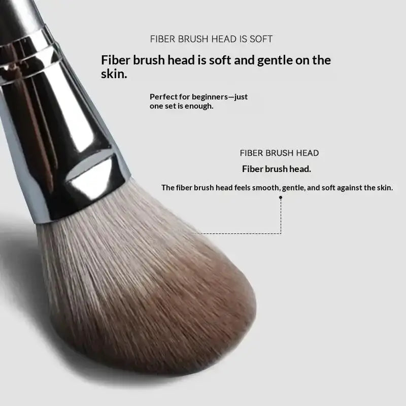 A soft fluffy fiber brush head with a sleek metallic handle in a silver professional synthetic makeup brush set