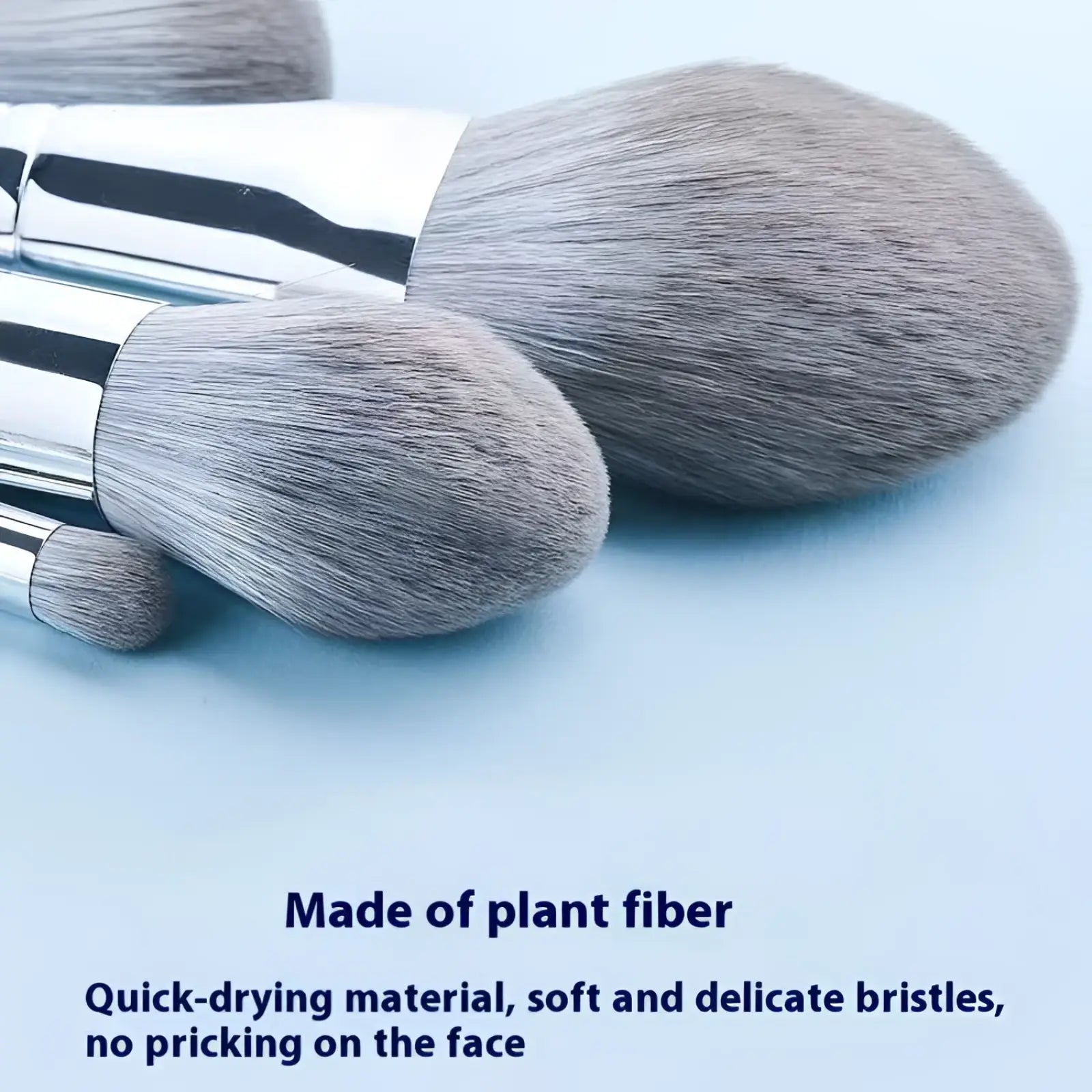 Set of three soft gray plant fiber makeup brushes with sleek silver handles from a 15-piece silver makeup brush set with case