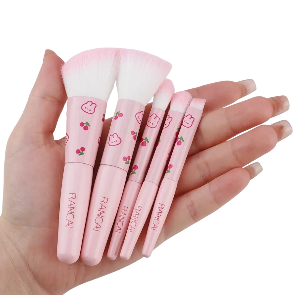 Pink rancai makeup brush set with five pieces featuring cherry and bunny designs on handles in a cute pink case