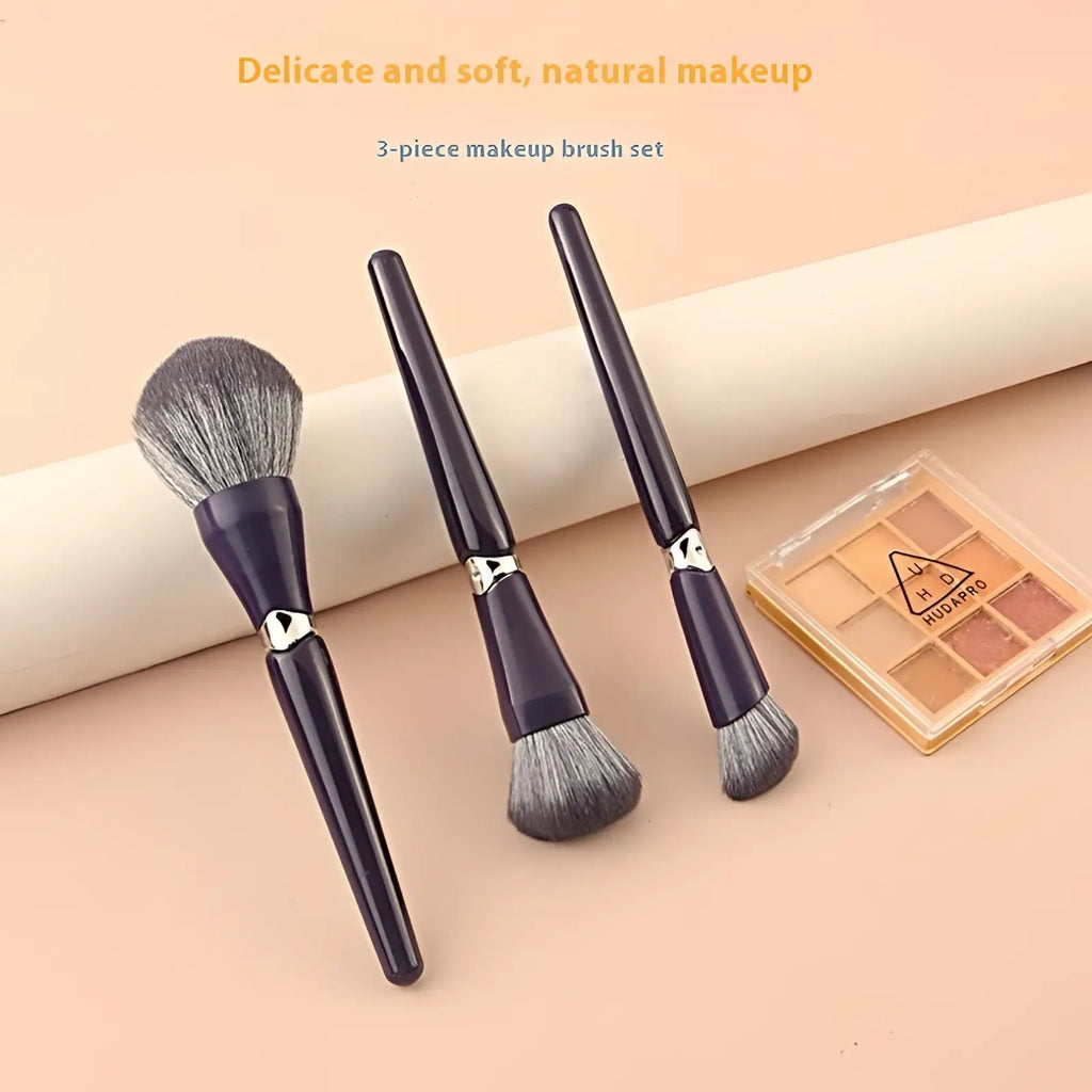 Set of three dark purple makeup brushes with silver accents and soft natural hair for face powder application
