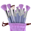 A set of 15 lavender and silver synthetic fiber makeup brushes with soft bristles in a matching plush storage pouch