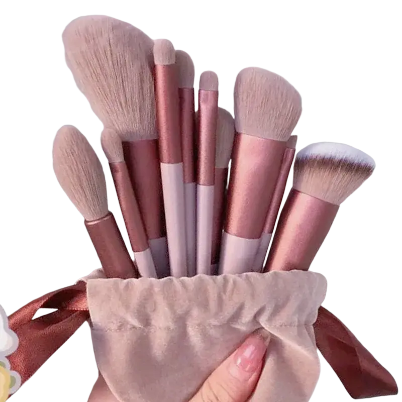 A set of 13 rose gold and white makeup brushes with soft bristles in a beige velvet pouch for eye shadow and cosmetic use