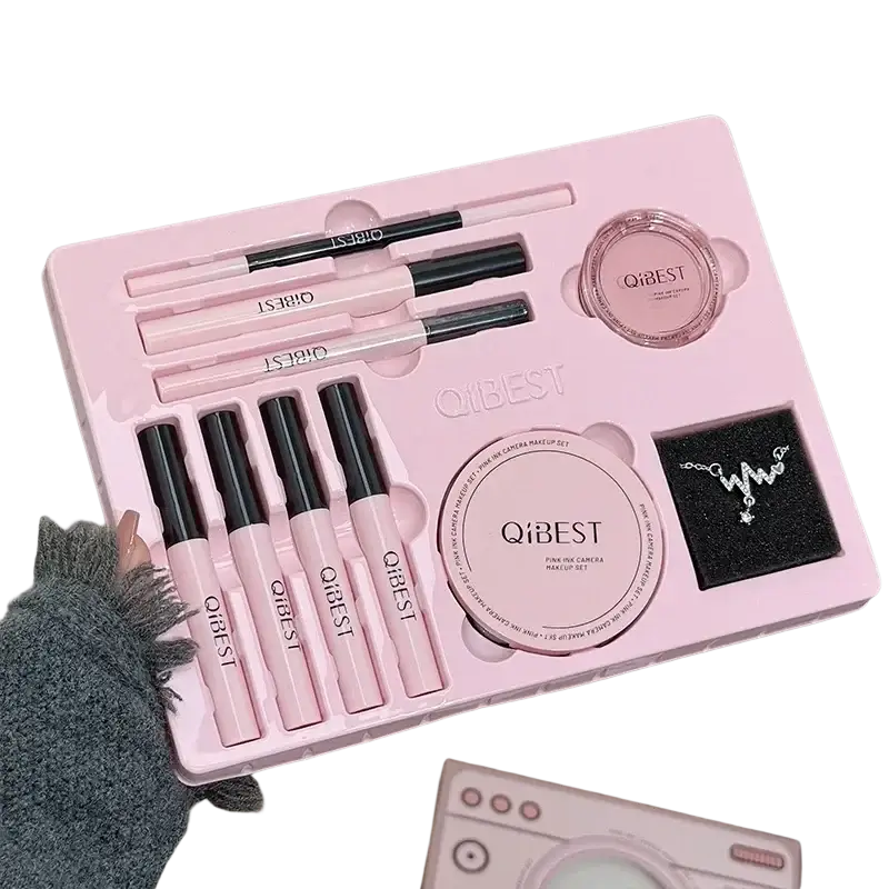 Pink qibest makeup sets featuring black-tipped pencils, blush compacts, and a silver necklace in molded tray