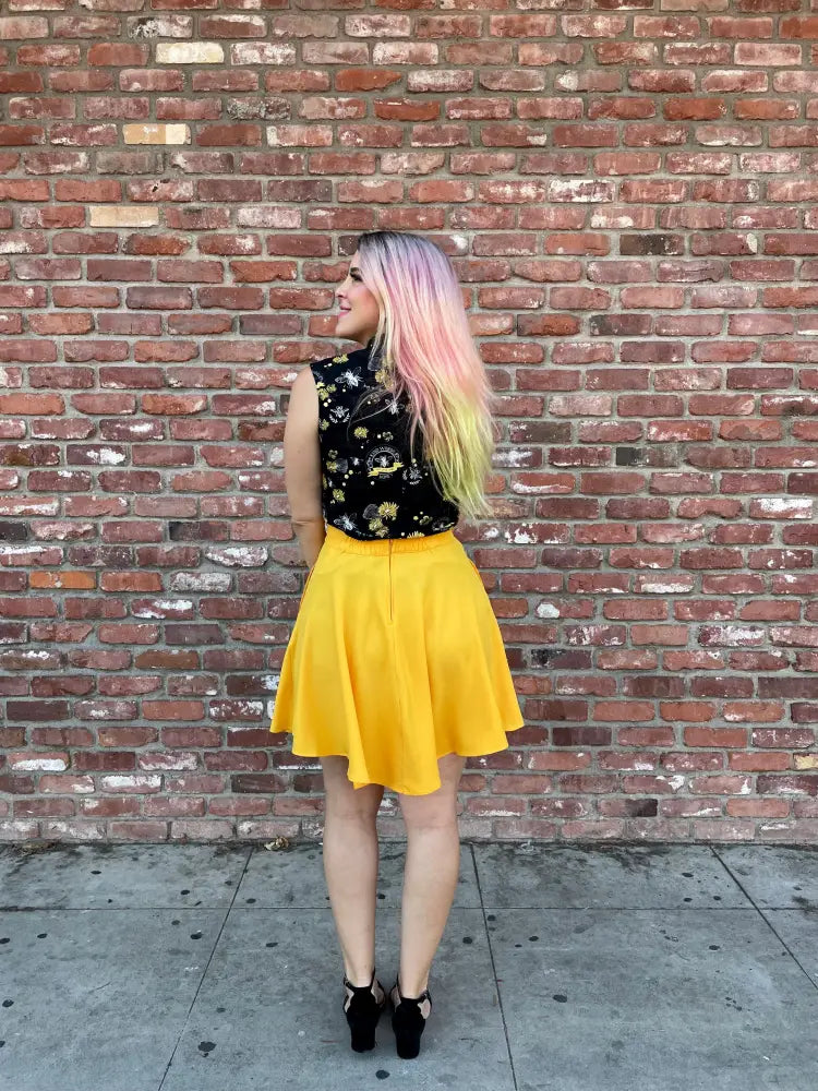 A vibrant vintage marigold yellow high waisted pleated skater skirt with pockets paired with a black floral top