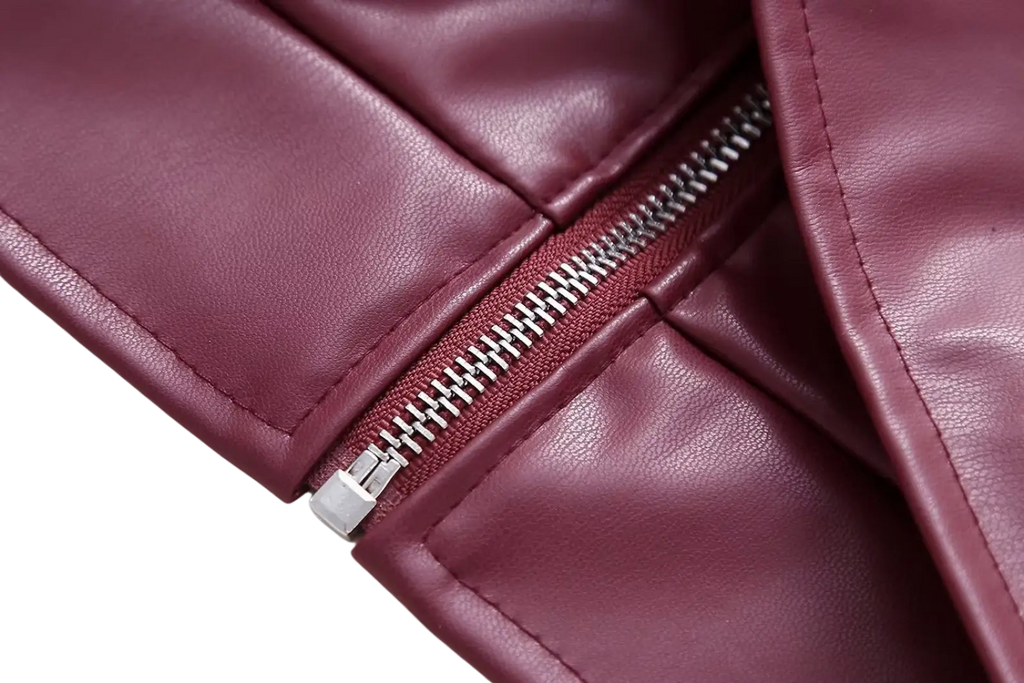 A close-up of a maroon faux leather biker jacket zipper with silver metal teeth and pull tab for women