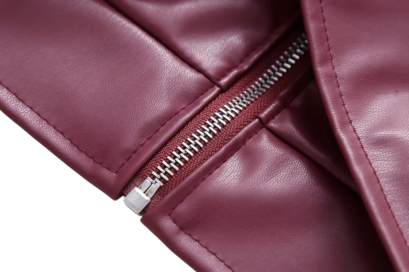 A close-up of a maroon faux leather biker jacket zipper with silver metal teeth and pull tab for women