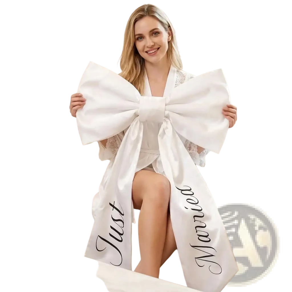 A large white satin just married car bow with black cursive script for wedding decoration