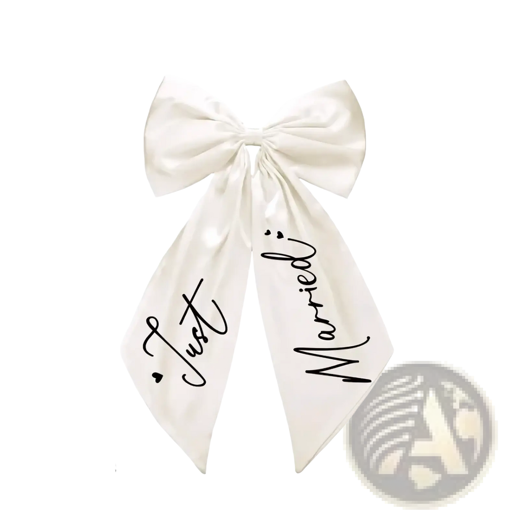 Just married car bow wedding decor with cream satin material and black cursive script on the ribbons