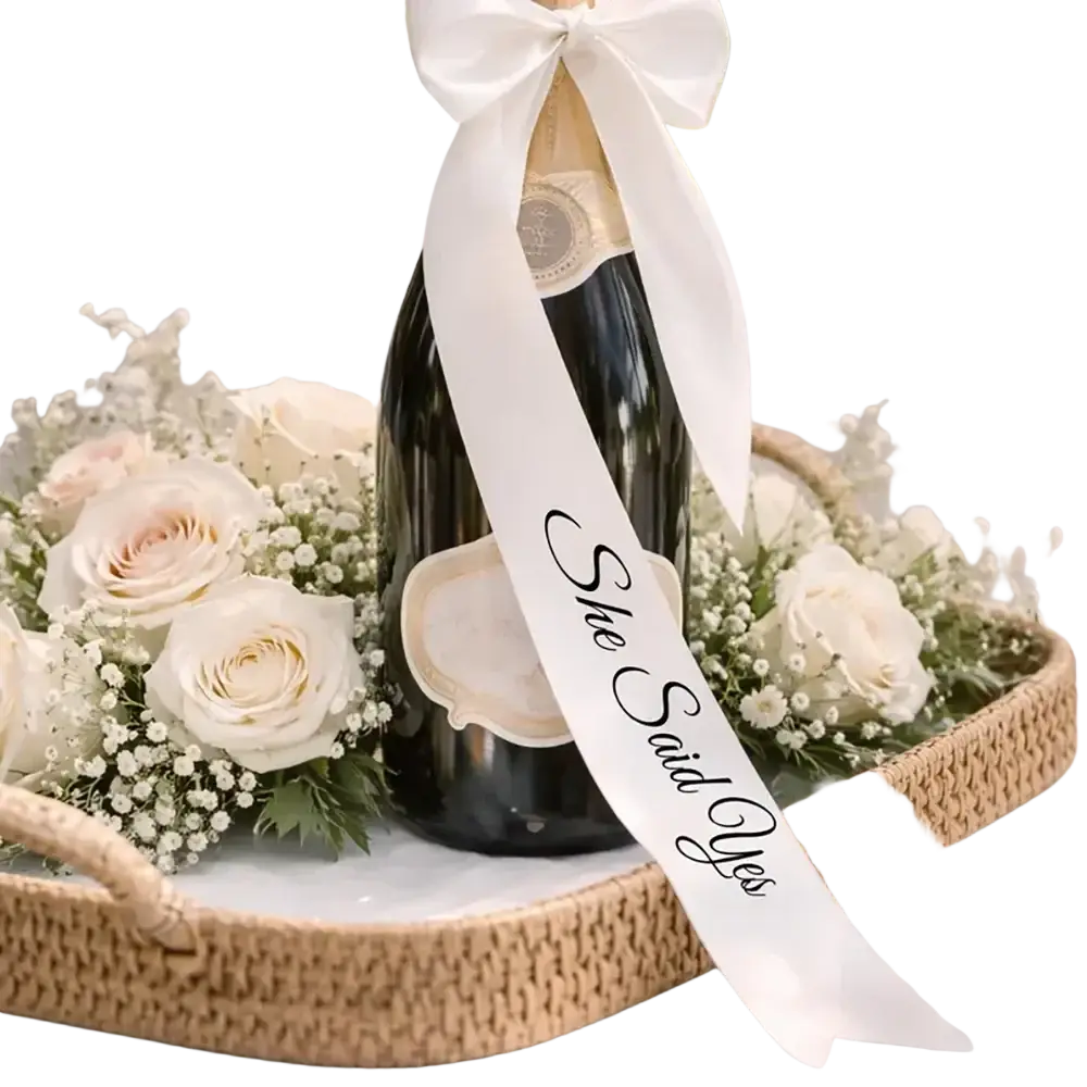 Just Married wine bottle ribbon wedding decor featuring a black champagne bottle with a white satin she said yes ribbon