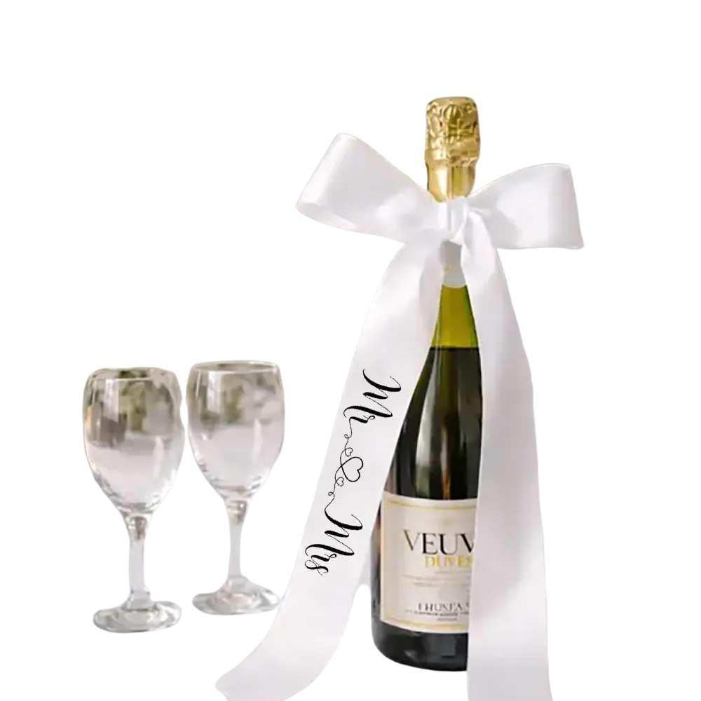 A bottle of veuve clicquot champagne with a white satin just married ribbon featuring mr and mrs script