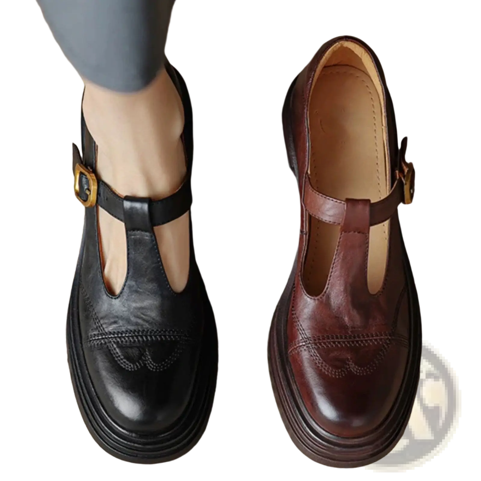 A pair of black and brown leather mary jane shoes with gold-tone buckles and decorative stitching on chunky heels