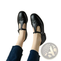 Black leather mary jane shoes with t strap brogue detailing and velvet lining in retro style