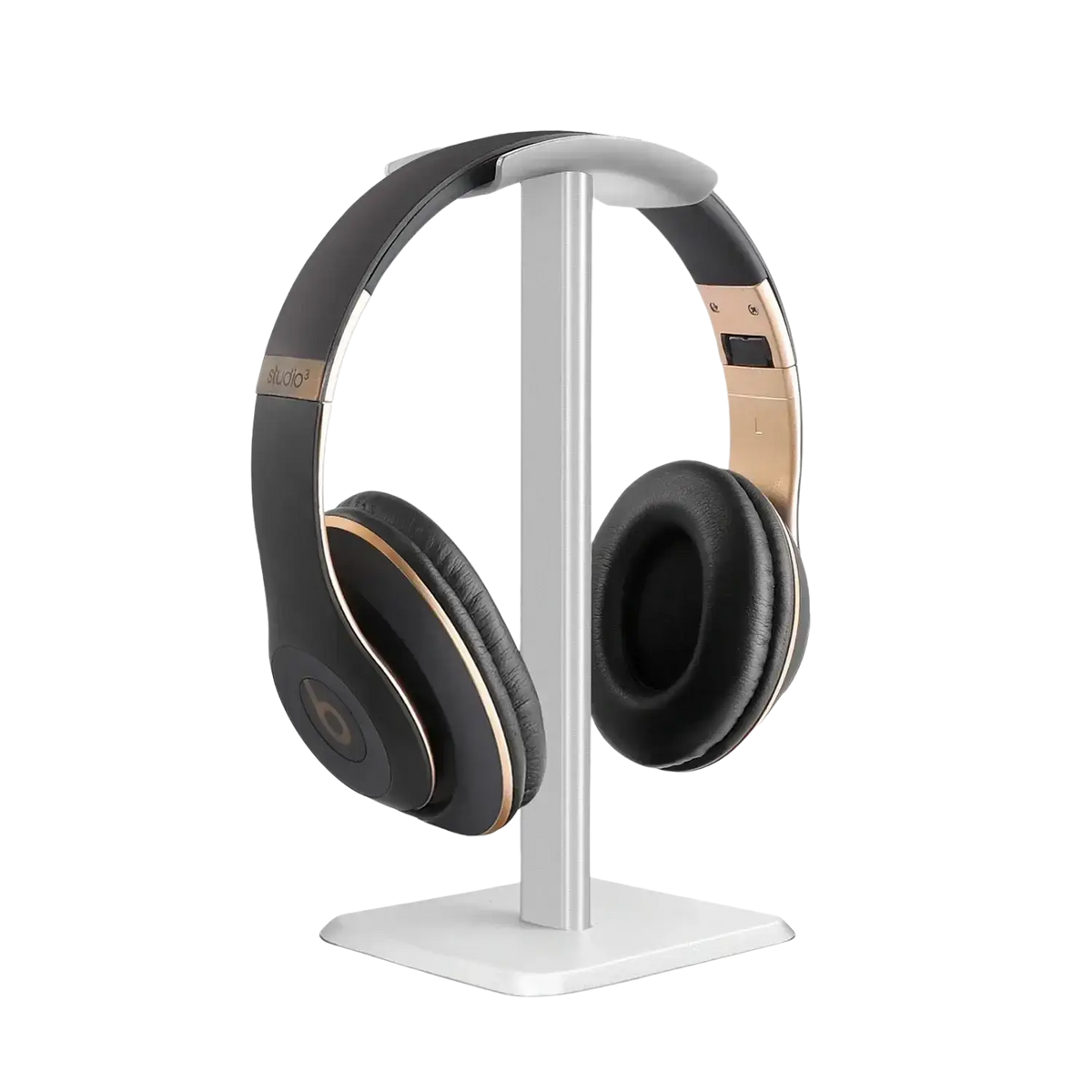 Black and gold beats studio3 wireless headphones with leather earcups on a matte aluminum headphone stand