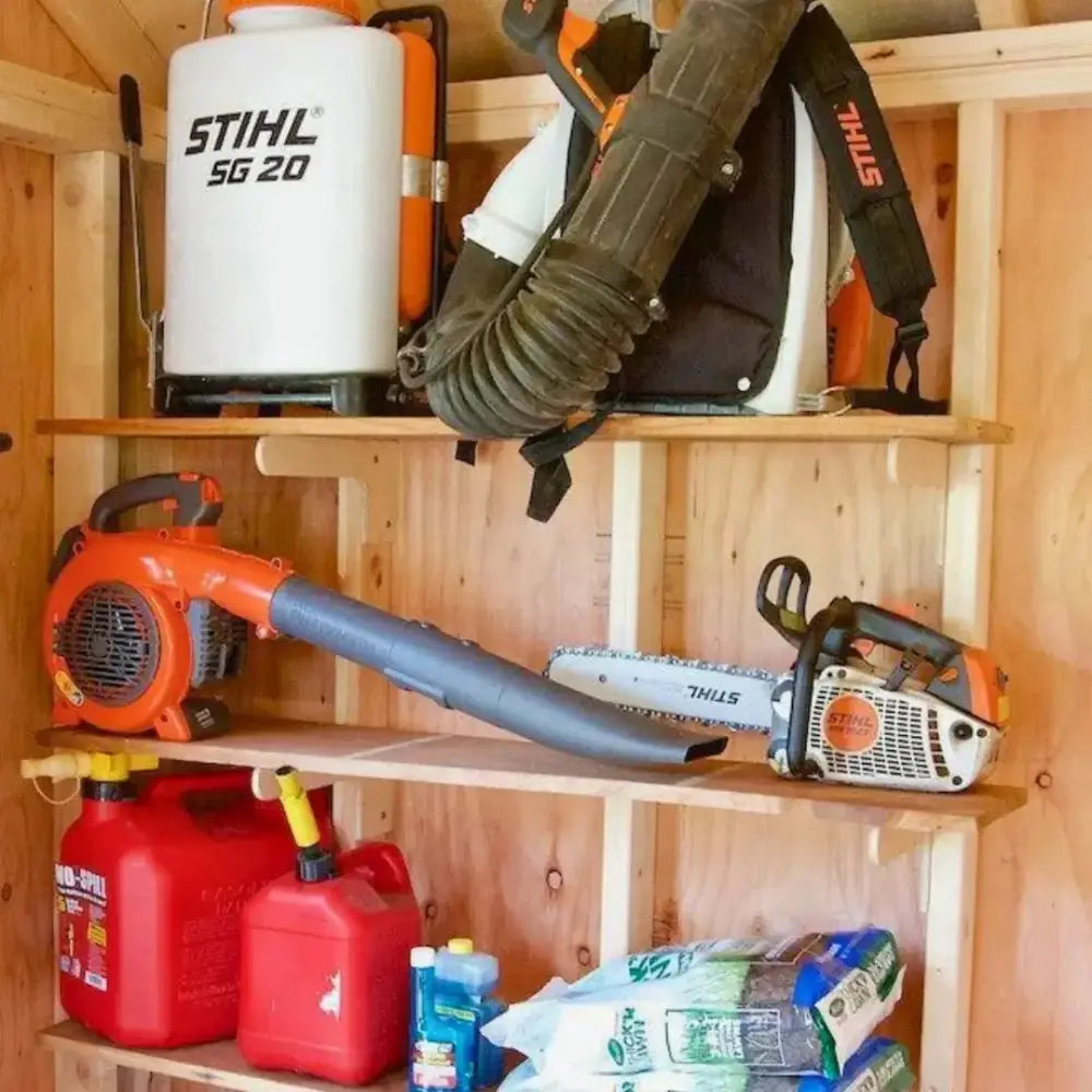 Orange and black stihl sg 20 backpack blower with white tank mounted on wooden shelves in max birch plywood stud shed kit