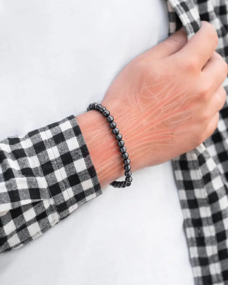 Black beaded max strength magnetic hematite bracelet with stainless steel clasp worn on a wrist