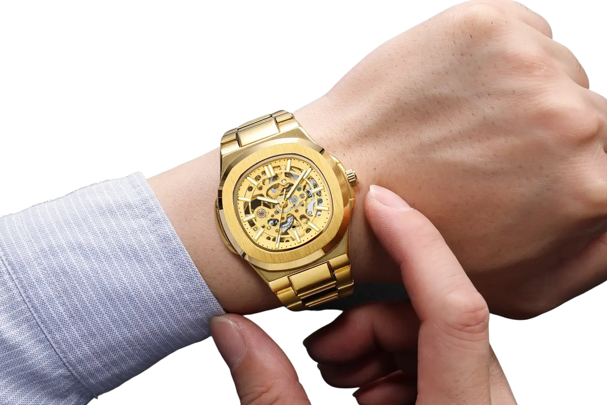 Mechanical skeleton watch in gold tone featuring exposed gears and a polished stainless steel bracelet