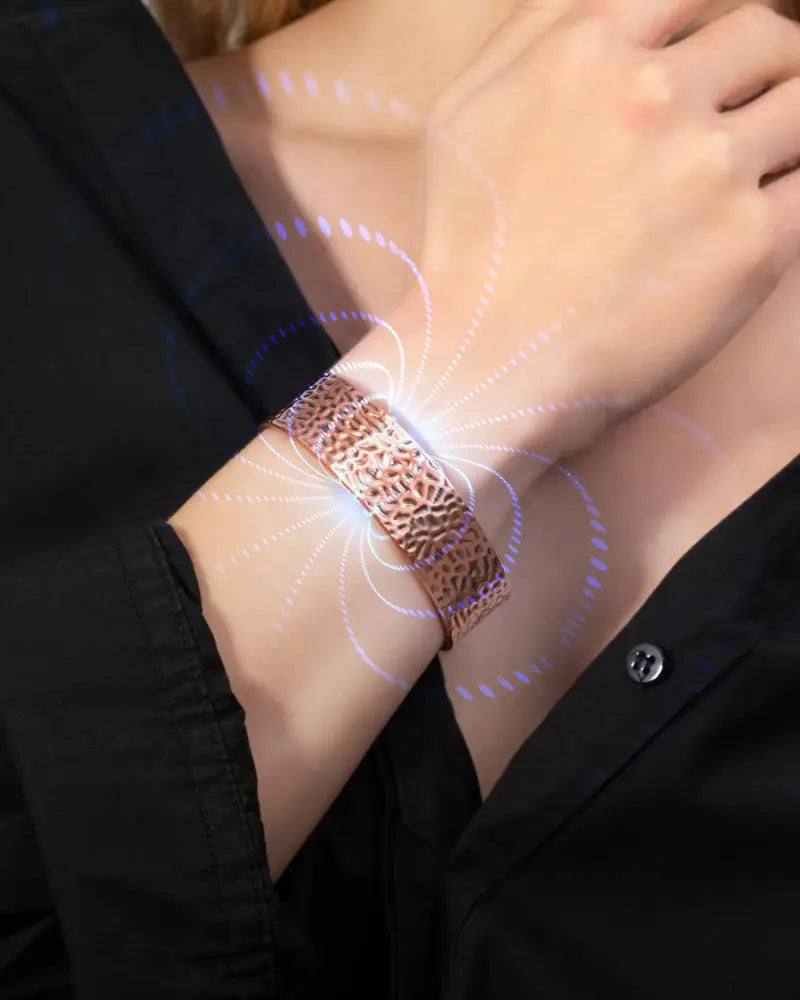 Rose gold textured metal fitness tracker band with glowing magnetic field effect in mega strength hammered copper magnetic therapy cuff