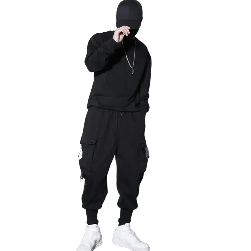 Men black cargo jogger pants with multiple pockets paired with a black hooded sweatshirt and white sneakers