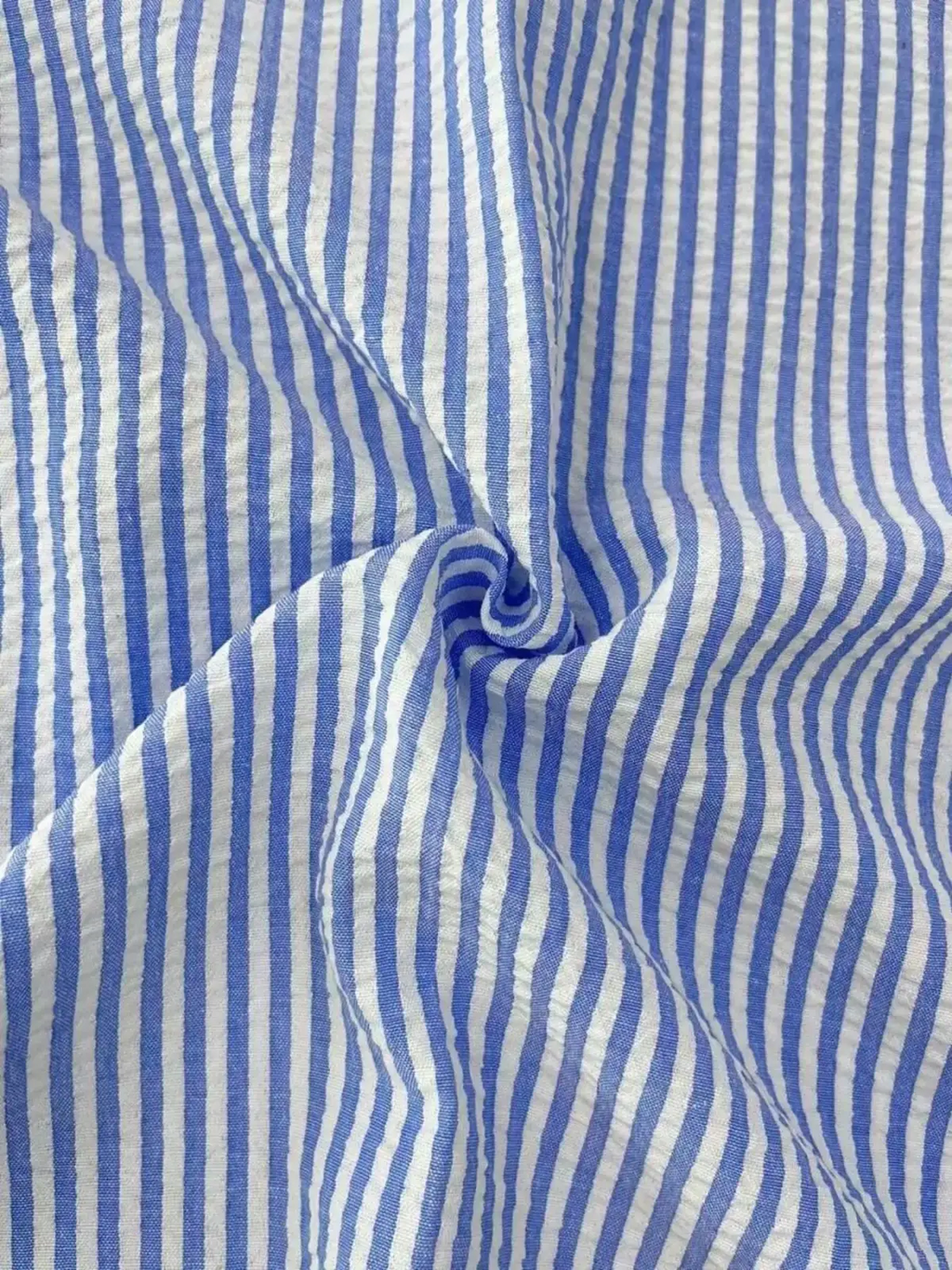 Men blue striped long sleeve casual button down shirt made of cotton fabric with a subtle crinkled texture