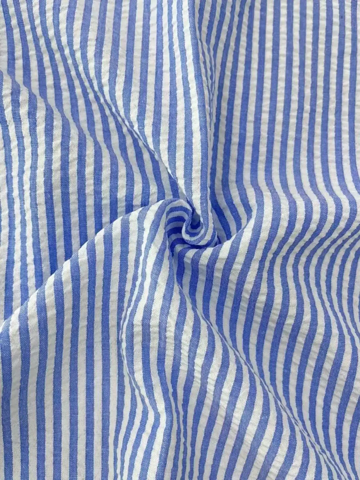 Men blue striped long sleeve casual button down shirt made of cotton fabric with a subtle crinkled texture