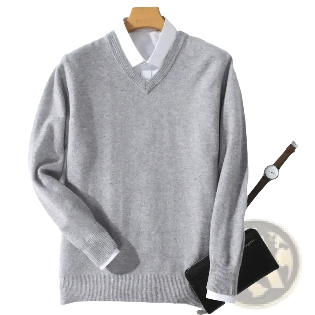 A soft heather gray men cashmere v neck pullover sweater with ribbed cuffs and hem hanging on a wooden hanger