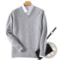 A soft heather gray men cashmere v neck pullover sweater with ribbed cuffs and hem hanging on a wooden hanger