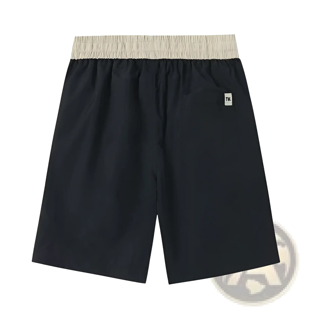 Back view of men casual straight cut nylon shorts in black with a beige elastic waistband and white logo patch