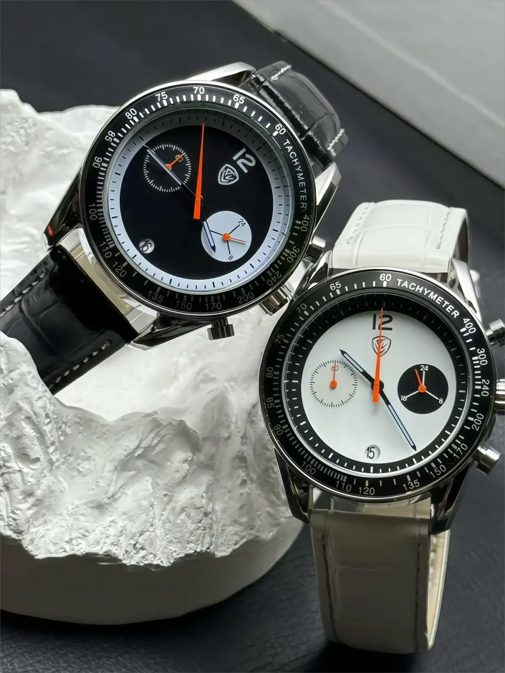 Men chronograph leather quartz watch with a sleek black and white dial, silver case, orange hands, and leather straps