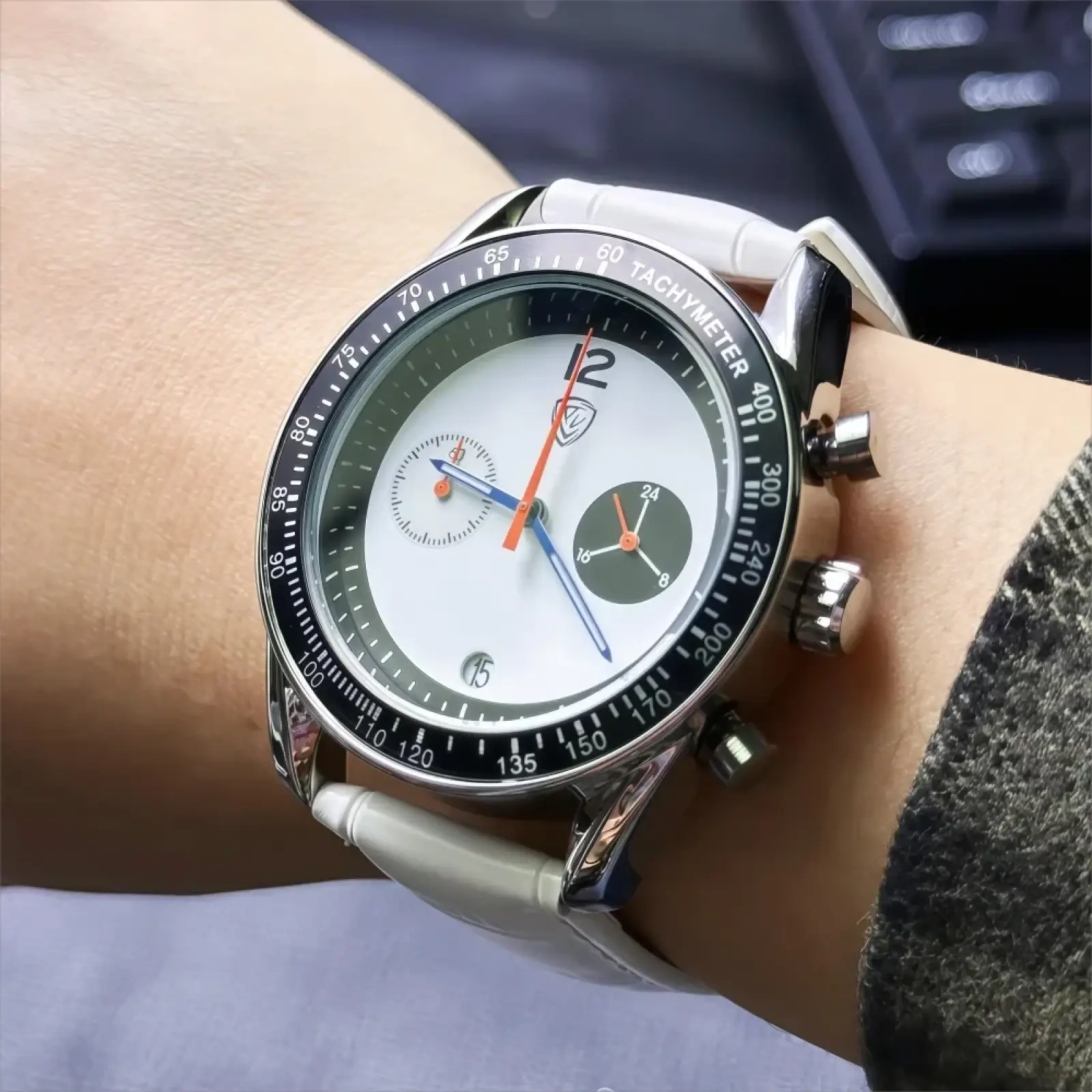 Men chronograph leather quartz watch with sleek silver case, white dial, black tachymeter bezel, and vibrant orange hands