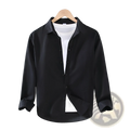 Men cotton linen long sleeve shirt in black with classic collar and rolled cuffs displayed on wooden hanger over white undershirt