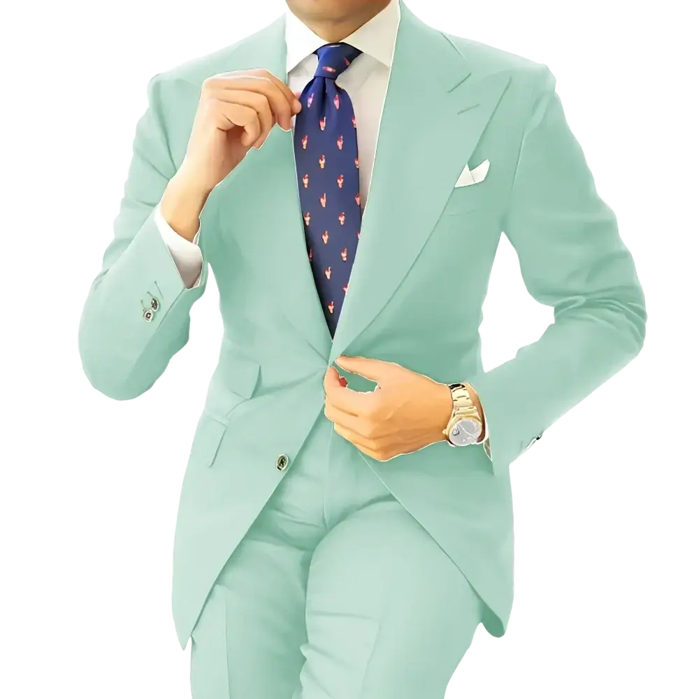 A man wearing a mint green suit with a white shirt and navy blue tie with pink flamingos in a dark gray tailored tuxedo blazer jacket